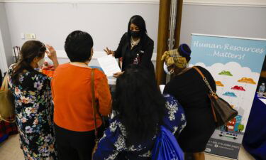 A recruiter speaks with job seekers during a Miami-Dade County job fair in Miami