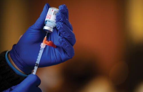A medical technician fills a syringe from a vial of the Moderna COVID-19 vaccine in Bates Memorial Baptist Church February 12