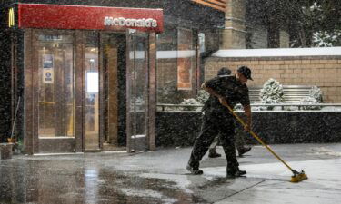 Companies are obsessed over worker pay. A McDonald's employee here sweeps snow away from the entrance on January 28