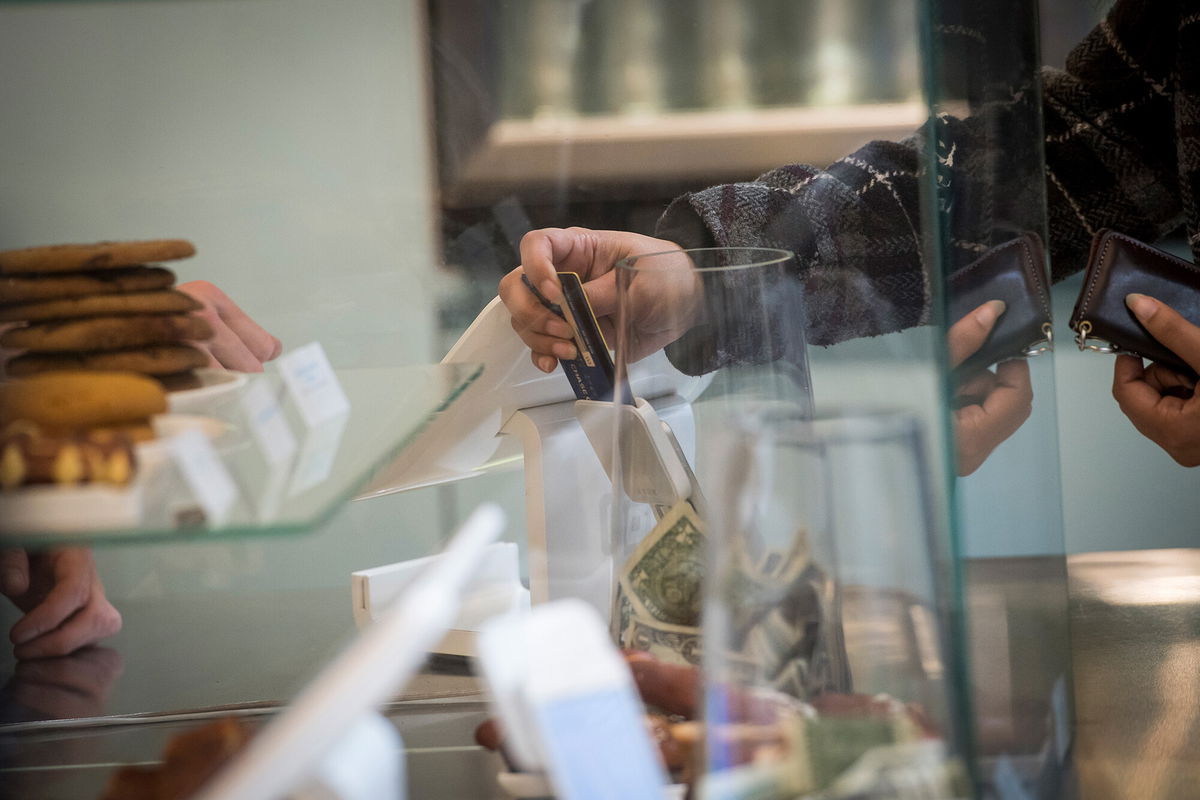 <i>David Paul Morris/Bloomberg/Getty Images</i><br/>Americans are getting themselves back into debt. A customer here is making a payment in San Francisco