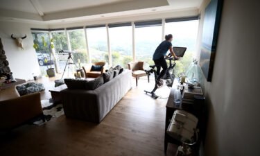 A person rides her Peloton exercise bike at her home on April 06