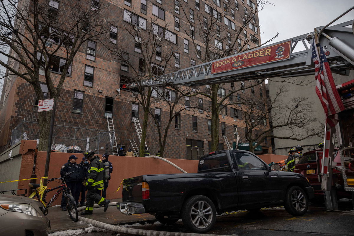 <i>Yuki Iwamura/AP</i><br/>Emergency personnel work at the scene of the fatal fire on Sunday.