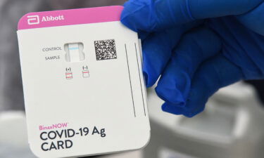 A health worker displays a Covid-19 rapid test kit at a drive through site at Barnett Park on November 9