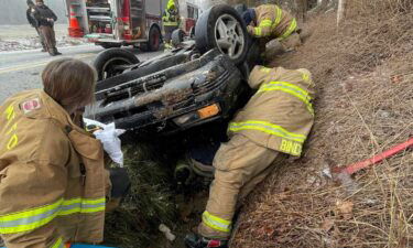 A woman and her two dogs were pulled to safety from a car that flipped over into a ditch.