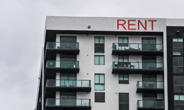 A "Rent" sign is displayed on an apartment building in Miami