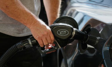 A person pumps gasoline into a car at a 76 gas station in Los Angeles