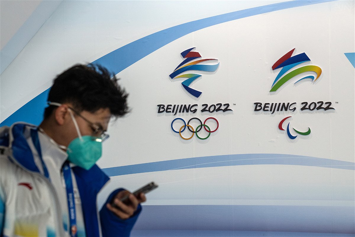 <i>Carl Court/Getty Images</i><br/>A man walks past Winter Olympics and Paralympics branding at the Main Press Centre on January 26 in Beijing