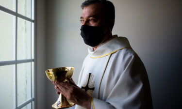 Father Andres Arango distributes Holy Communion while wearing a mask at St. Gregory's Catholic Church in Phoenix on May 10