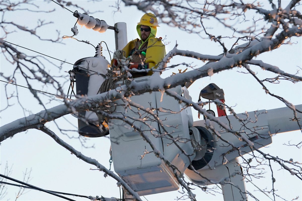 <i>Steven Senne/AP</i><br/>A lineman stands in an elevated platform Sunday while repairing damaged power lines in Chatham