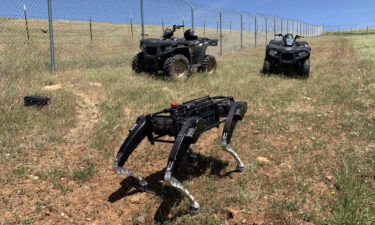 A handout photo from the Department of Homeland Security shows a robot dog built by Ghost Robotics operating alongside ATVs in the southwestern United States.