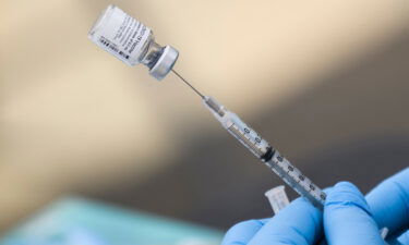 A syringe is filled with a first dose of the Pfizer Covid-19 vaccine at a mobile vaccination clinic during a back-to-school event.