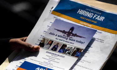 A job seeker holds job flyers and pamphlets during the hiring fair at the SoFi Stadium in Los Angeles on September 9