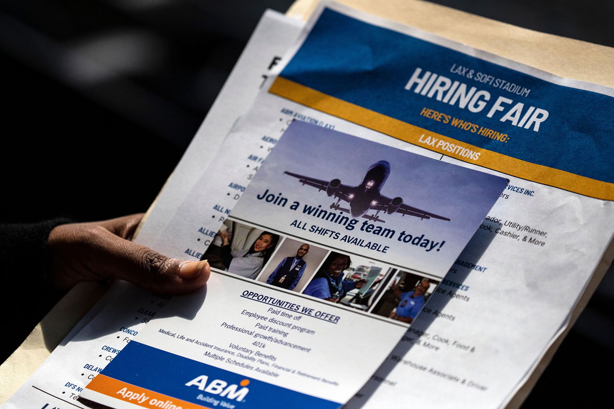 <i>Etienne Laurent/EPA-EFE/Shutterstock</i><br/>A job seeker holds job flyers and pamphlets during the hiring fair at the SoFi Stadium in Los Angeles on September 9
