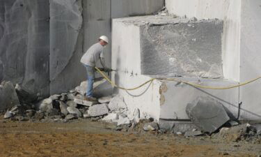 A quarry worker drills holes in a block of granite in Elberton