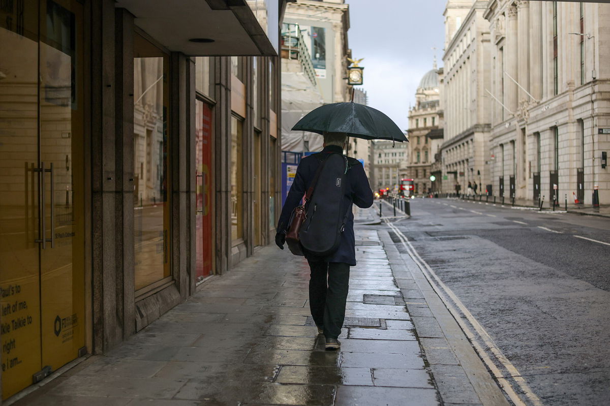 <i>Hollie Adams/Bloomberg/Getty Images</i><br/>A morning commuter carrying an umbrella while walking through the City of London