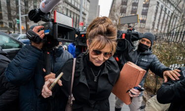 Former Alaska Gov. Sarah Palin pushes past members of the media as she leaves Federal court