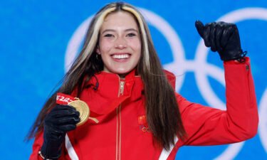 Gold medalist Eileen Gu celebrates on the podium after winning the freestyle skiing women's halfpipe.