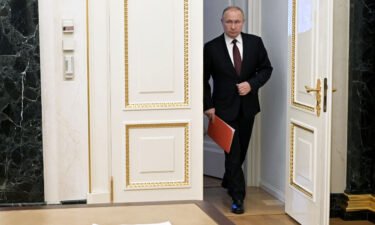 Russian President Vladimir Putin enters a hall before a meeting with members of the Security Council via a video link in Moscow