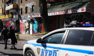 An NYPD vehicle is parked in front of the building where Christina Yuna Lee lived as people take photos on February 14 in the Chinatown neighborhood in New York City.