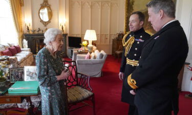 Queen Elizabeth II speaks with Rear Admiral James Macleod and Major General Eldon Millar (right) in the Oak Room at Windsor Castle on February 16.