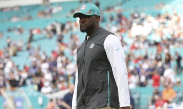 Miami Dolphins head coach Brian Flores stands on the field prior to an NFL football game against the New England Patriots