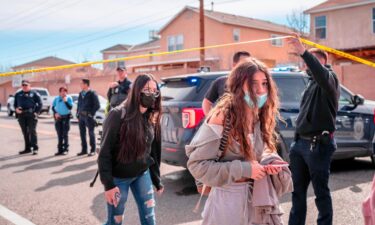 Police and students are seen after a fatal shooting near an Albuquerque high school Friday.