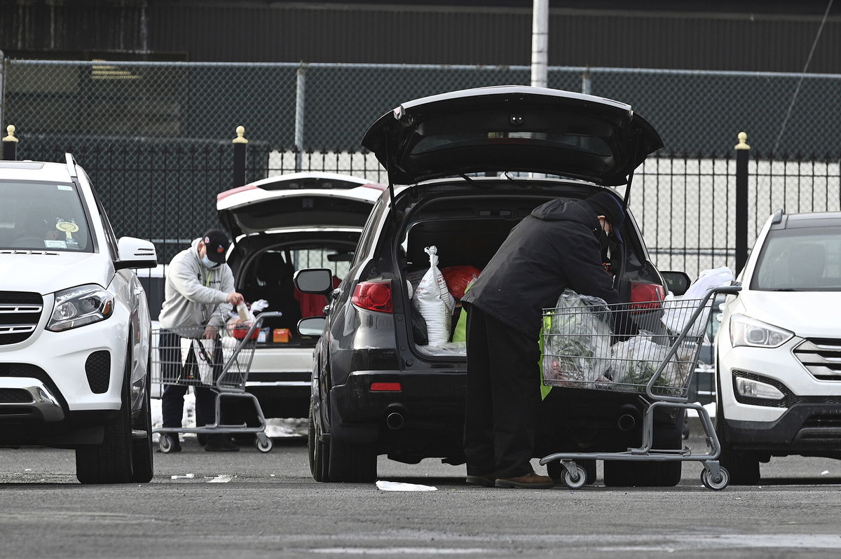 <i>Anthony Behar/Sipa USA/AP</i><br/>Two people load their cars with groceries in the parking lot of a Chinese supermarket in the Elmhurst neighborhood of the Queens borough of New York City on January 13.