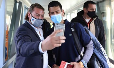 A man takes a selfie with Djokovic as he arrives at Nikola Tesla Airport in Belgrade