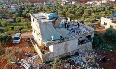 People inspect a destroyed house following an operation by the U.S. military in the Syrian village of Atmeh