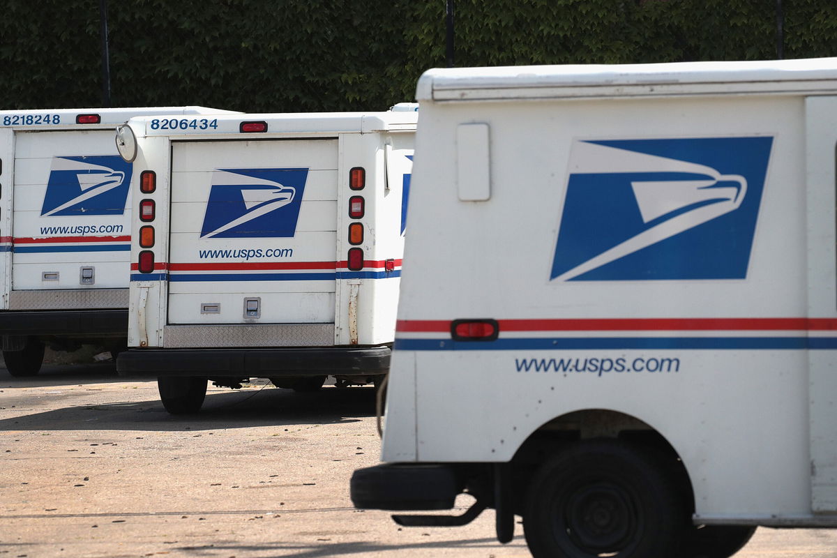 <i>Scott Olson/Getty Images</i><br/>United States Postal Service (USPS) trucks are parked at a postal facility on August 15