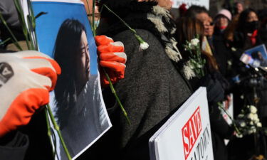 A person holds a photo of Christina Yuna Lee as people gather for a rally protesting violence against Asian-Americans in the Chinatown neighborhood in New York City on February 14.