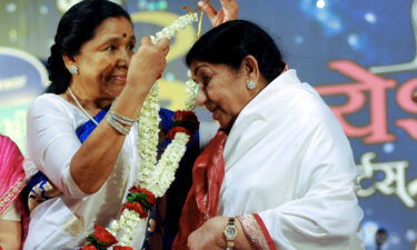 Indian Hindi and Marathi language Bollywood playback singer Lata Mangeshkar (right) is greeted by her sister Asha Bhosle during an awards ceremony in 2013.