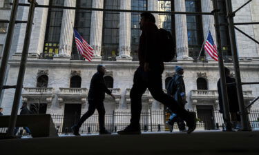 People walk past the New York Stock Exchange (NYSE) on Wall Street on February 11