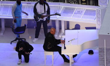 Eminem kneels next to Dr. Dre during the Pepsi Super Bowl LVI Halftime Show at SoFi Stadium on February 13