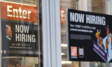 A "Now Hiring" sign outside a Home Depot store in New York
