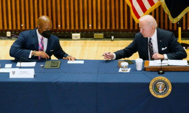President Joe Biden hands a note to New York City Mayor Eric Adams during a discussion on gun violence strategies