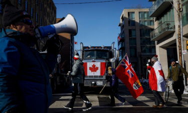 Supporters pass by a honking truck near Queens Park on February 5