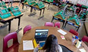 A teacher interacts with students virtually while sitting in an empty classroom during a period of Non-Traditional Instruction (NTI) at Hazelwood Elementary School on January 11