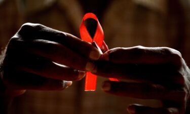 An HIV-positive person from the Support and Care Centre of the Sumanahalli Society prepares 'red ribbons' on the eve of World Aids Day in Bangalore.