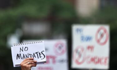 People gather at City Hall to protest vaccine mandates on August 09