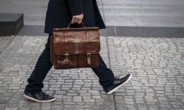 A man carries a briefcase as he walks through the Financial District