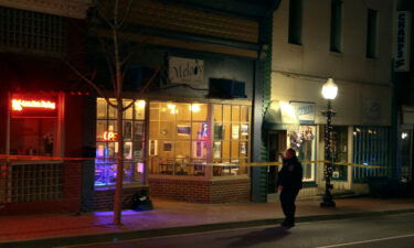 A police officer stands outside the Melody Hookah Lounge in Blacksburg