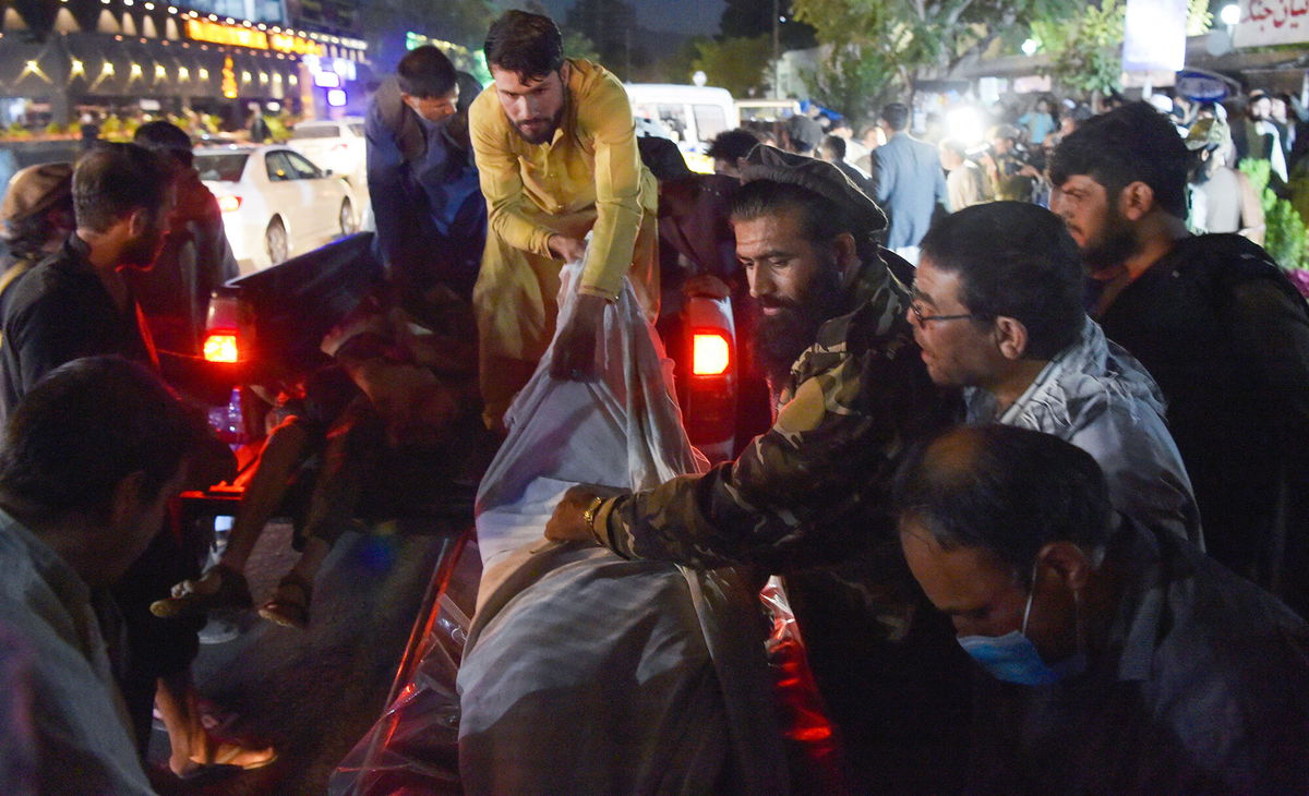 <i>Wakil Kohsar/AFP/Getty Images</i><br/>Volunteers and medical staff unload bodies from a pickup truck outside a hospital outside the airport in Kabul on August 26