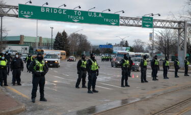 Police officers move in to clear traffic and protesters blocking access to the Ambassador Bridge during a demonstration in Windsor