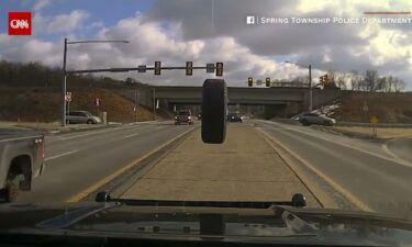 Police dashcam captures a runaway tire smashing into a police vehicle's windshield.