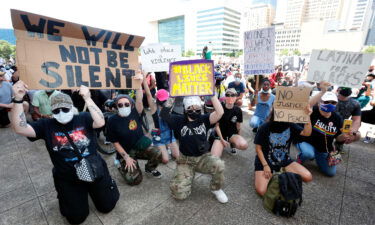 Protesters take a knee to demonstrate in front of Dallas City Hall in downtown Dallas