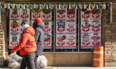 A federal official warns on high inflation. Various sale items are here advertised in the window of a supermarket in New York on February 6.