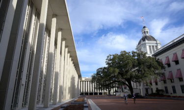People walk between the Florida State Capitol building