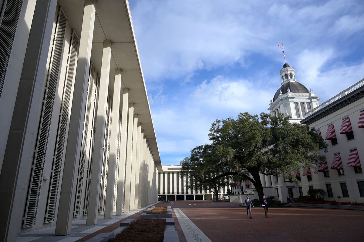 <i>Phelan M. Ebenhack/AP</i><br/>People walk between the Florida State Capitol building