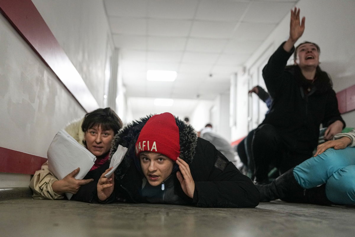 <i>Evgeniy Maloletka/AP</i><br/>People lie on the floor of a hospital during shelling in the Ukrainian city of Mariupol on March 4.